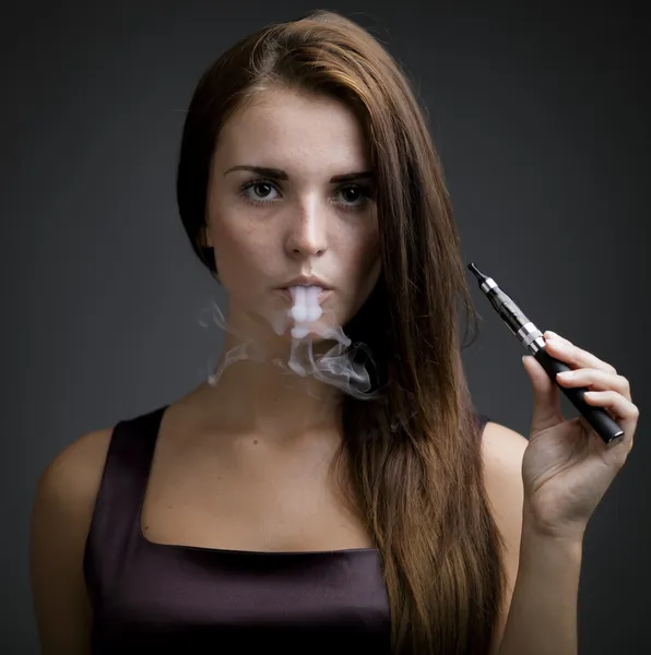 Person holding an ecigarette with smoke, promoting E-cigarettes Houston alternatives on a gray background.