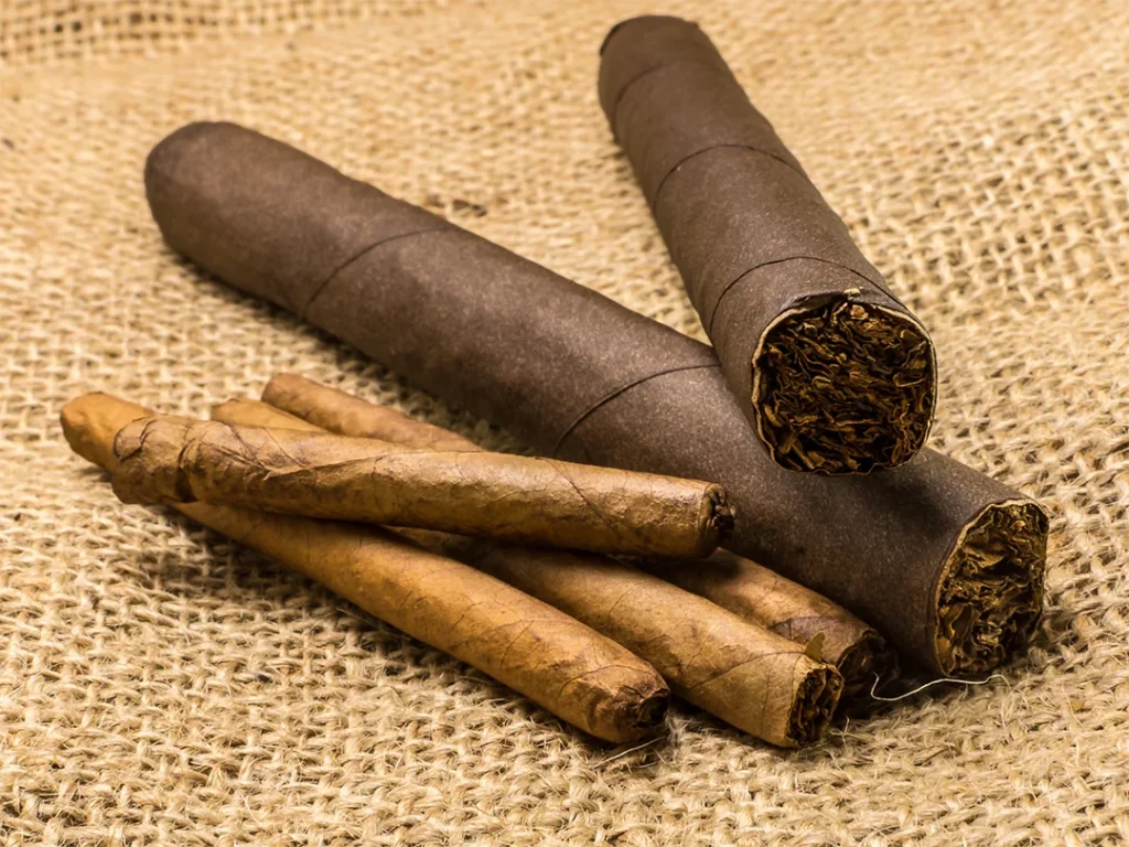 A variety of cigars and tobacco on a burlap background, showcasing products from a tobacco store Houston.