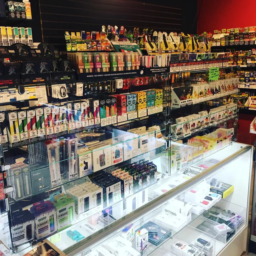 A vibrant tobacco shop in Houston with shelves stocked with Fumari hookah tobacco, Al Fakher, and NARA products, showcasing a variety of flavors and brands.