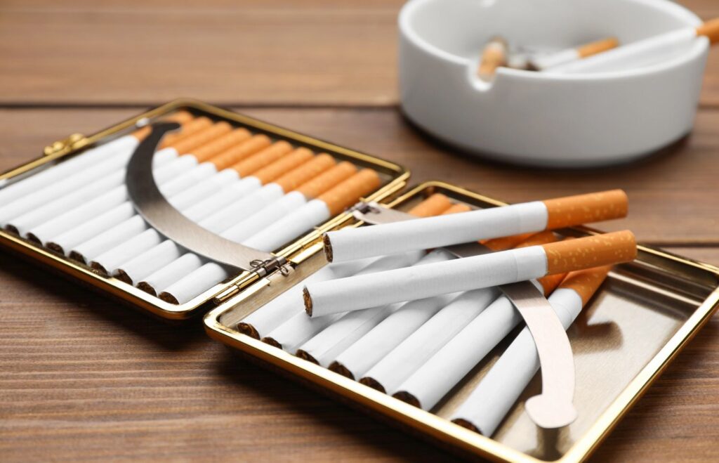 Open cigarette cases with cigarettes and an ashtray on a wooden table, great for a cigarette shop Broken Arrow.