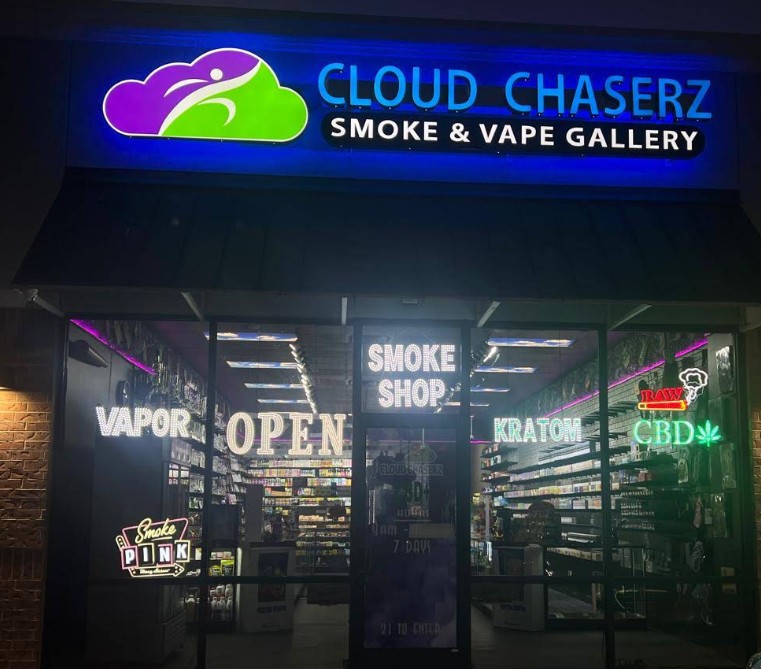 Neon-lit Cloud Chaserz Smoke & Vape Gallery storefront, offering cigarettes at Cigarette Shop Broken Arrow, with "Open" sign.