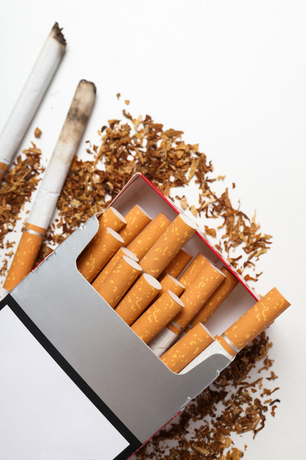 An open pack of cigarettes with loose tobacco and smoked butts, featured at Cigarette Shop Houston.