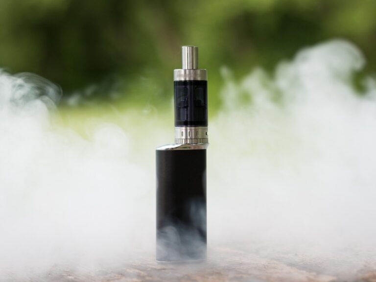 Premium e-cigarettes in Houston: Close-up of a sleek black vape pen with visible e-liquid tank and misty exhale.