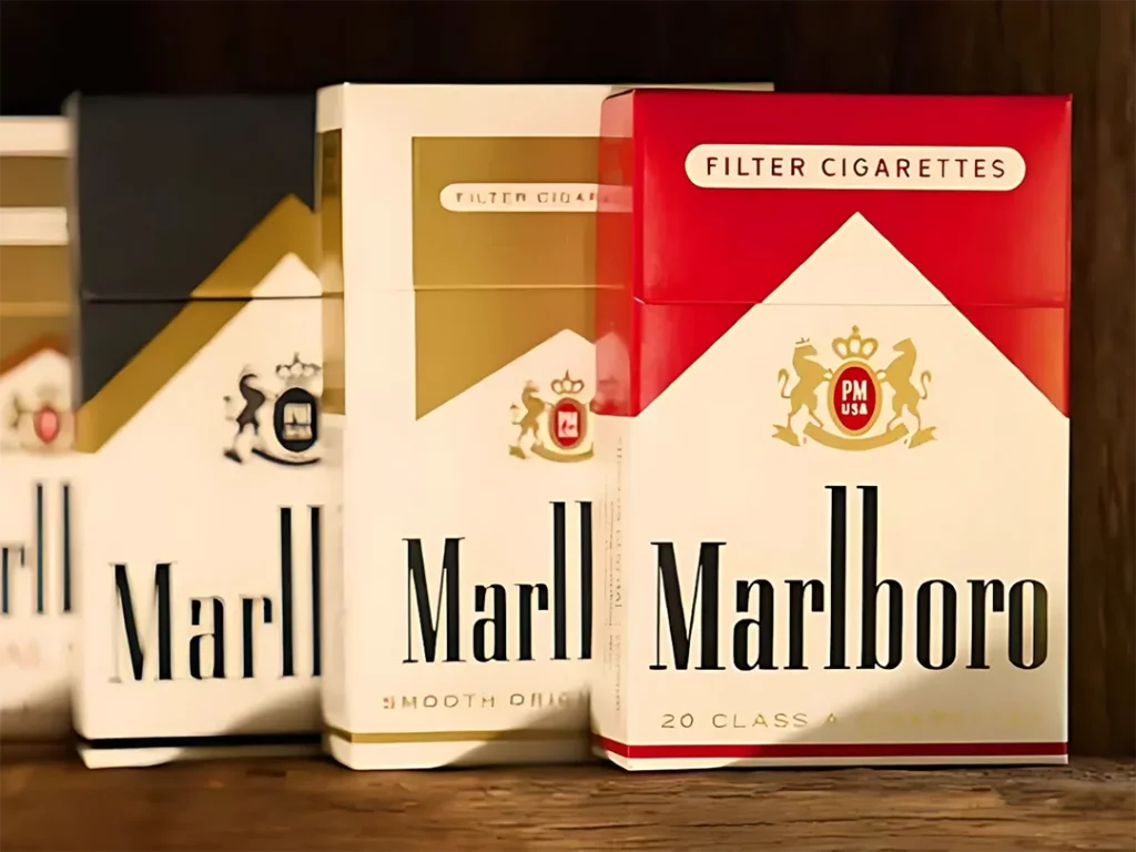 Person holding a pack of cigarettes at a cigarette shop in Houston with shelves of tobacco products.