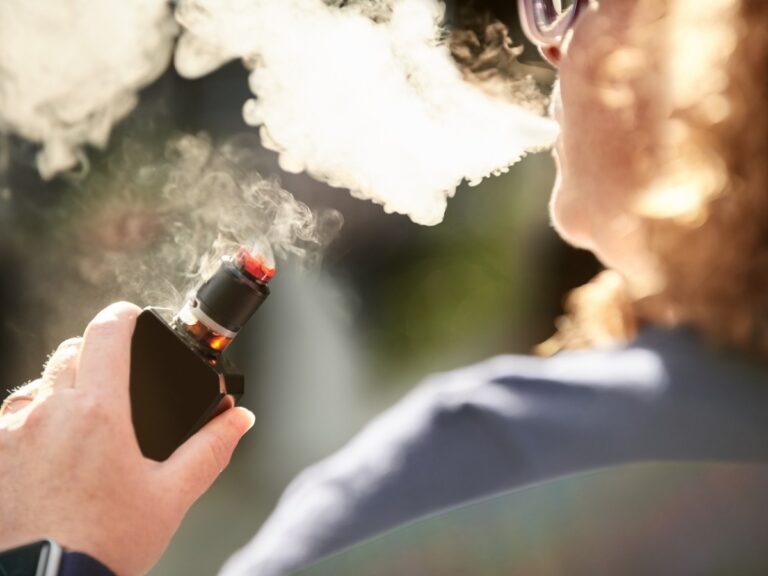 Individual enjoying a vape session with a high-quality device from Vape Shop Houston, captured in a natural setting.