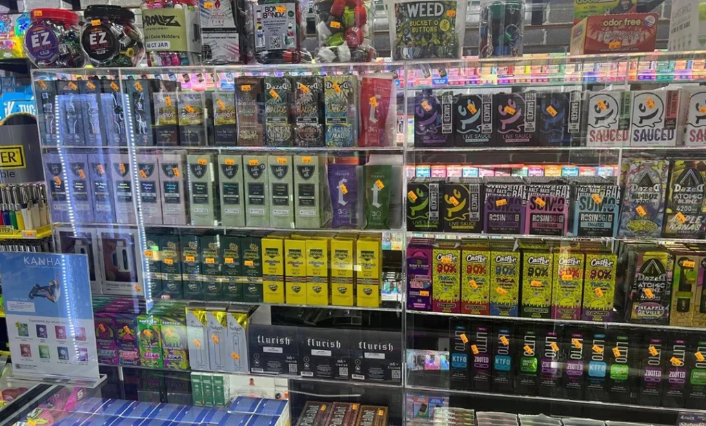 Colorful shelves with vapes, edibles, and accessories at Cigarette Shop Broken Arrow, featuring various cigarette brands and prices.