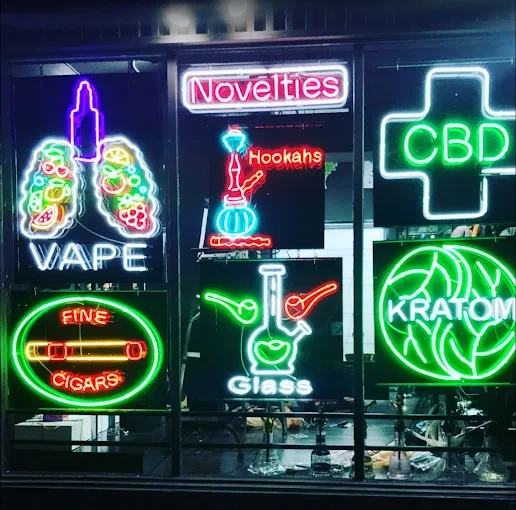 Neon signs advertise vape, hookahs, and CBD at a head shop in Houston.