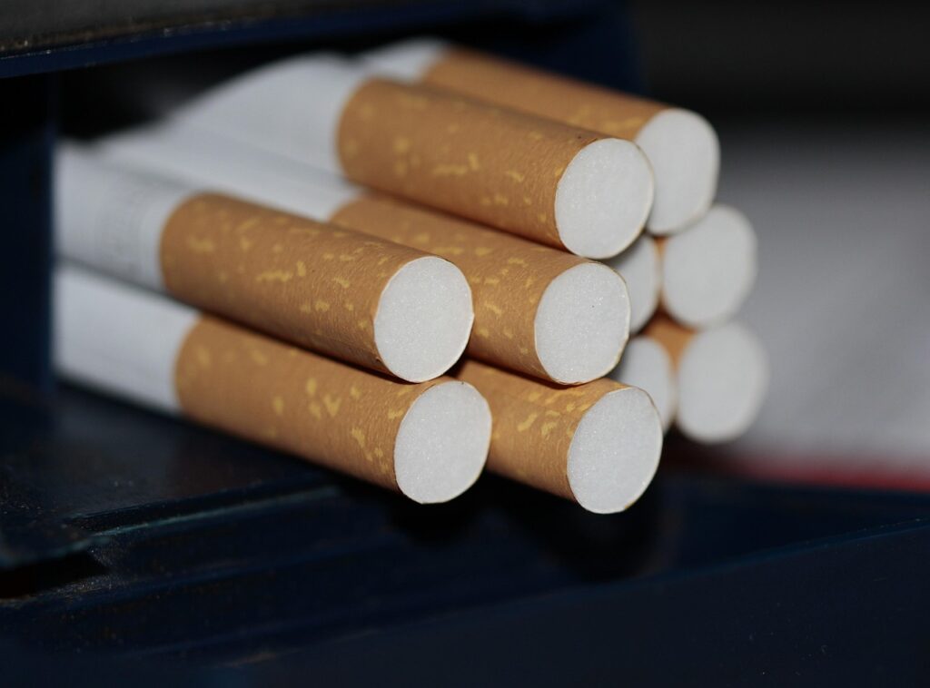 A stack of new filter-tipped cigarettes neatly packed in a dark carton, stocked daily at cigarette shop broken arrow.