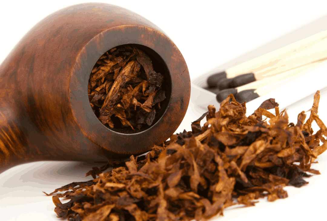 Rustic pipe setup with tobacco and candlelight—authentic smoking gear from Tobacco Store Sapulpa.