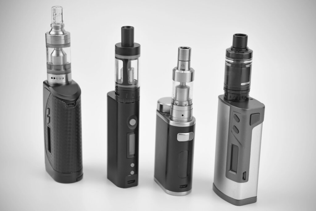 Four vape devices with digital screens and sleek finishes—shop top brands at the leading vape store in Tulsa.