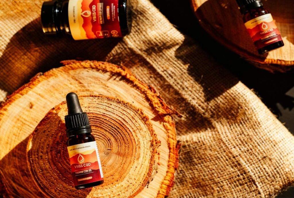 Natural VIB3S CBD tincture bottles on wooden rounds – available now at CBD Store Owasso.