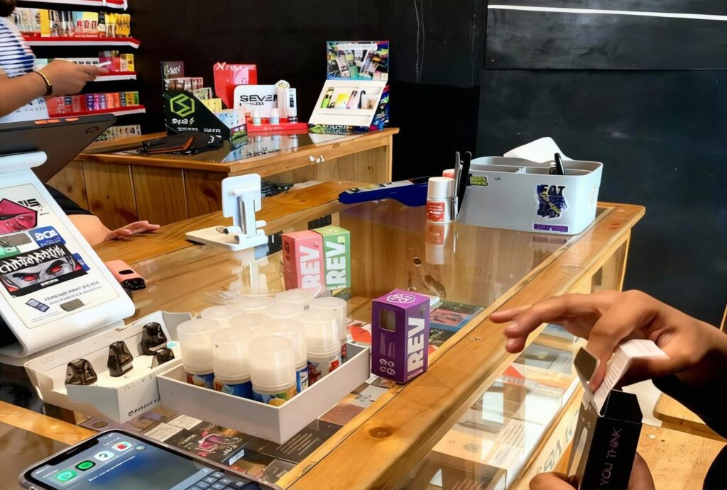 Customer checking out Delta 8 disposables and juices at friendly Delta 8 Store Owasso counter.