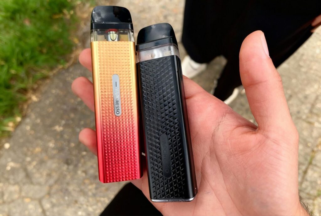 Vaporesso XROS Pro gradient gold-red and matte black pods held outdoors – Vape Store Broken Arrow favorites.