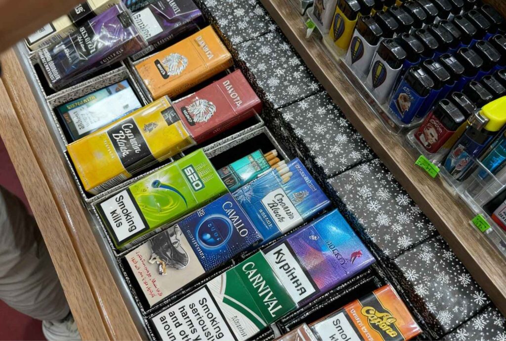 Diverse cigarette packs like Carnival and Davidoff on display counter at Cigarette Shop Broken Arrow.
