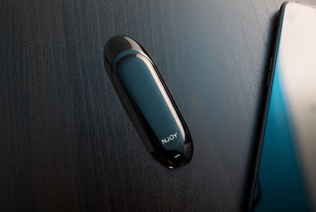 Sleek black NJOY vape pod device on a dark table; the best selection of Nicotine Pods Tulsa has to offer.