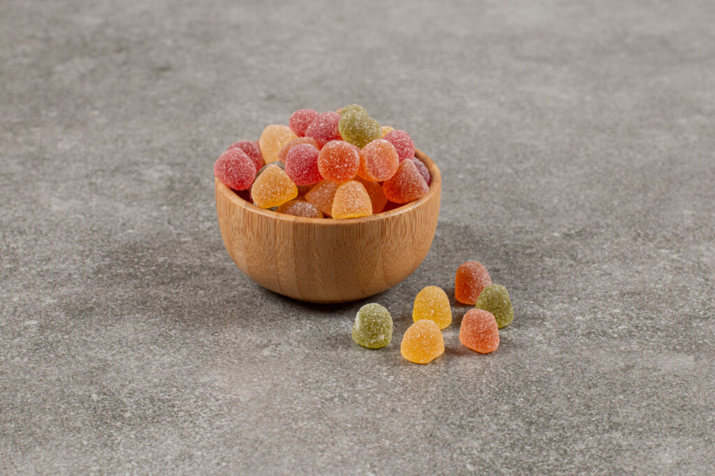 Assorted Delta 8 gummies in wooden bowl at trusted Delta 8 store Broken Arrow.