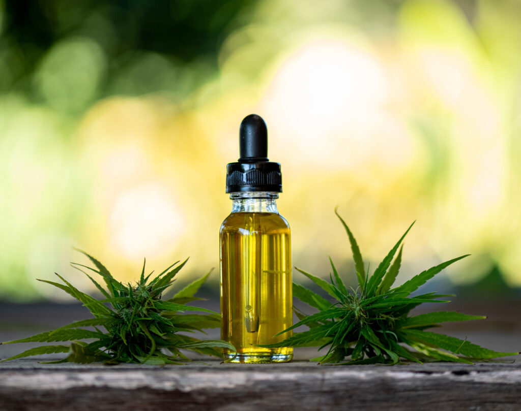 Premium CBD oil in Owasso with hemp buds on wood. Discover the best CBD shop Owasso for natural products.