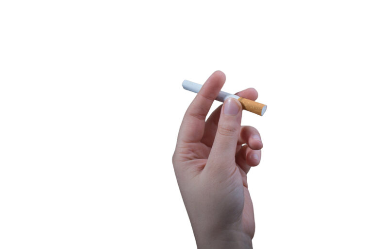 Hand holding a single filtered cigarette against white background, showcasing premium tobacco products at cigarette shop in Broken Arrow.