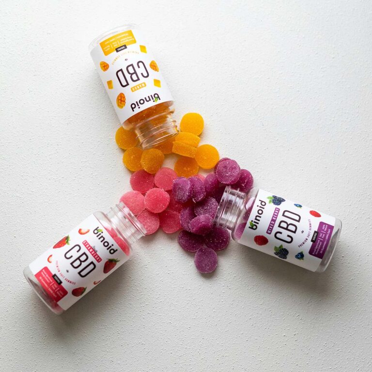 Three jars of premium fruit-flavored CBD gummies spilling out. Stock up on edibles at your favorite CBD Store Tulsa today.