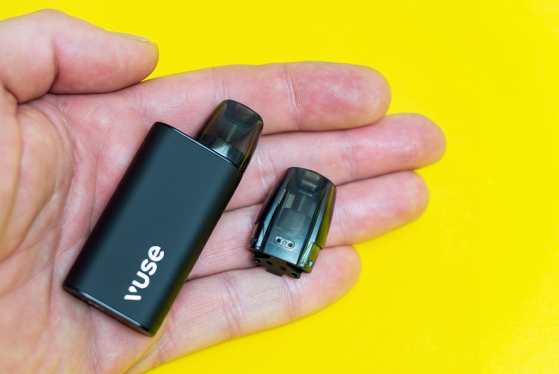 Close-up of a disassembled black Vuse vape, showing the open Nicotine Pods Tulsa cartridge for refilling.
