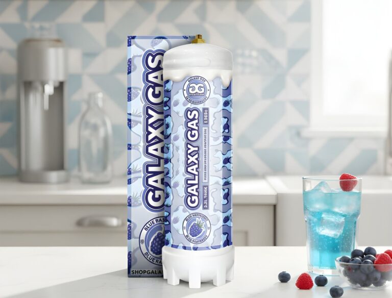 Blue Raspberry n20 owasso Galaxy Gas culinary infusion tank with retail box and blue cocktail in a kitchen setting.