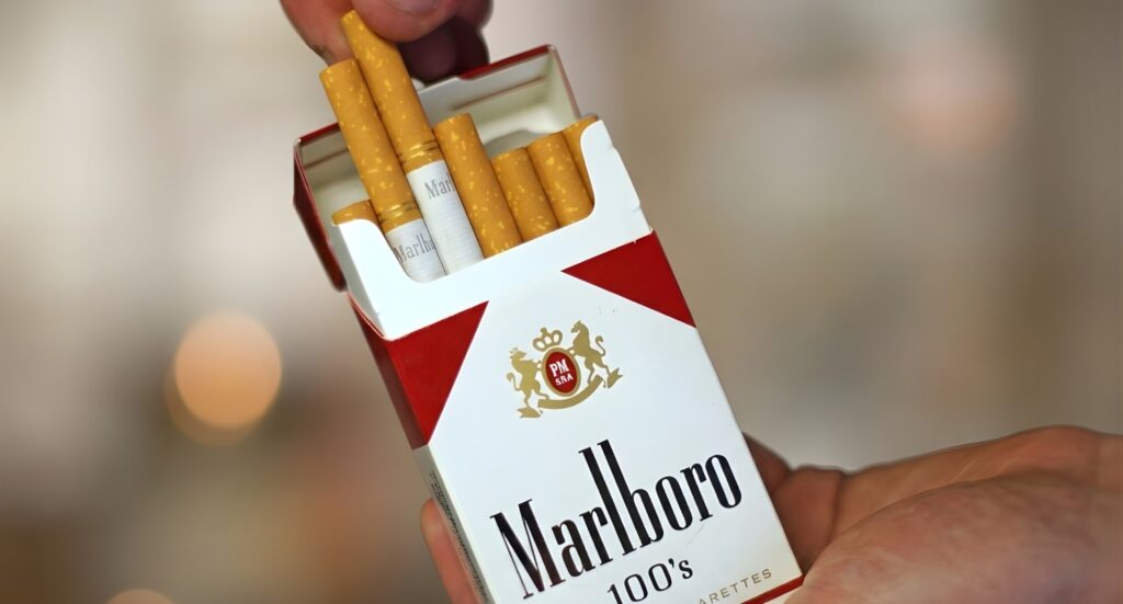 Hand holding a pack of Marlboro 100s cigarettes, showcasing the top-tier brands available at our tobacco shop Tulsa.