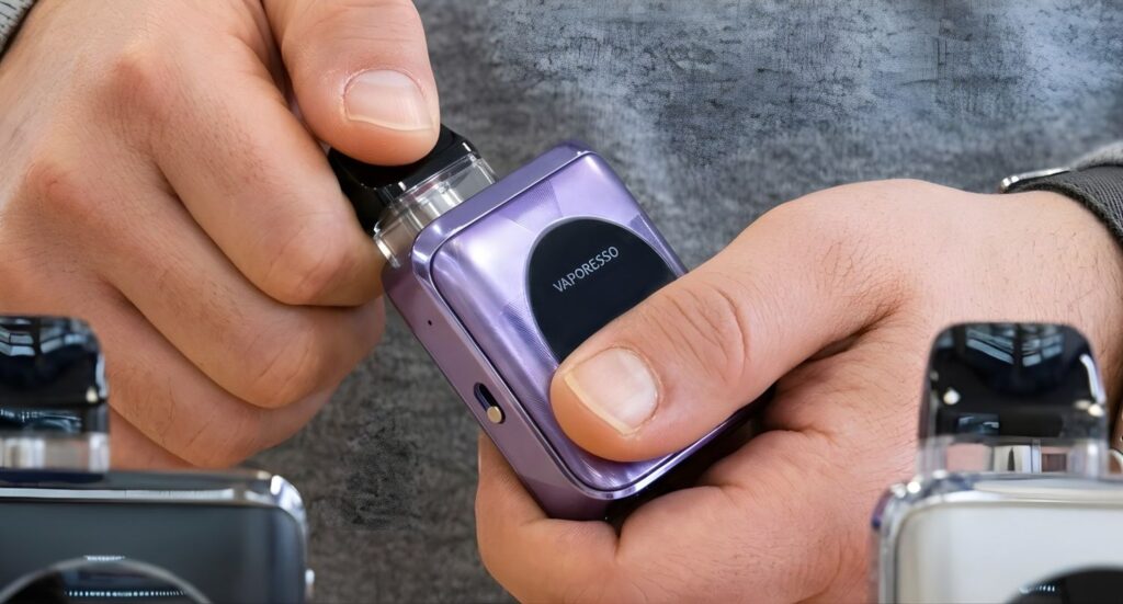 Hands adjusting a purple Vaporesso XROS Nano pod system, found at the best vape shop Tulsa for compact luxury vaping.