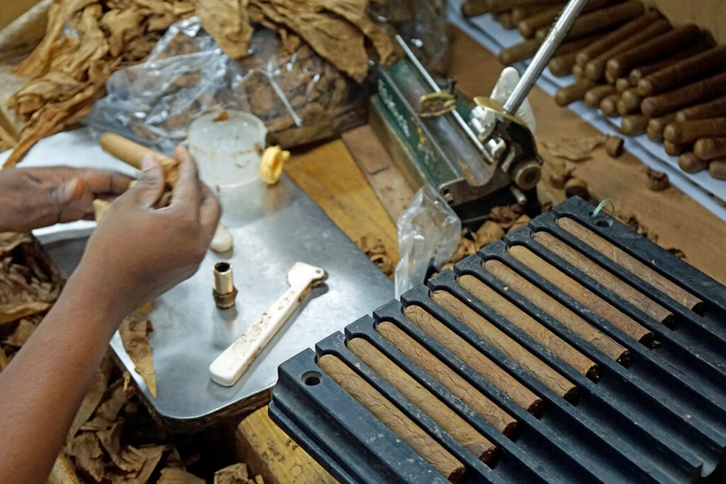 An artisan's hands meticulously crafting hand-rolled cigars. See the authentic process at our premier cigar shop Sapulpa.