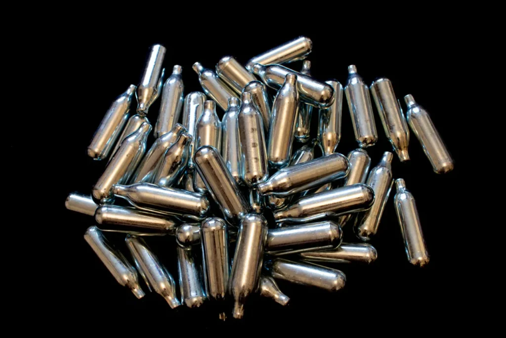 A bulk supply of silver N2O cartridges on black. Order professional whip cream chargers owasso for delivery.