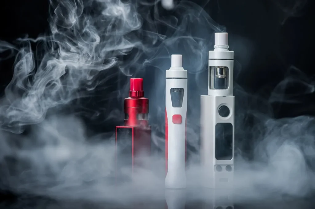 E-cigarettes generating large vapor clouds against a dark background, highlighting high-performance e-cigarettes broken arrow can find online.