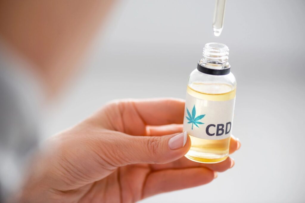 Person holding a premium hemp tincture bottle from a CBD store Owasso for wellness and natural health relief. 