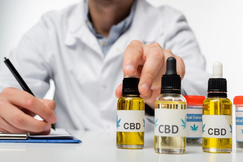 Professional consultant displaying oil tinctures for a client at a leading CBD store Owasso for medical hemp use.