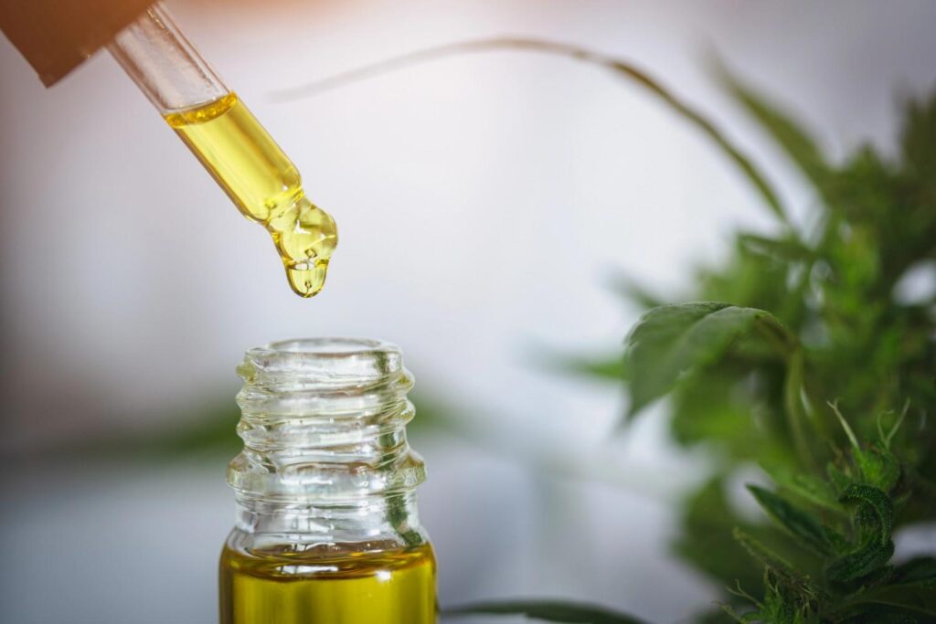 A glass oil dropper dripping potent golden extract into a bottle at a premium cannabis and CBD store Tulsa. 