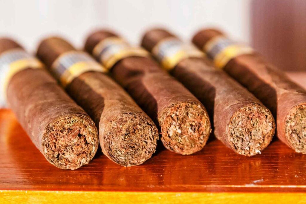 A stack of authentic luxury Cuban cigars arranged neatly on a wooden surface at a cigar shop Broken Arrow.