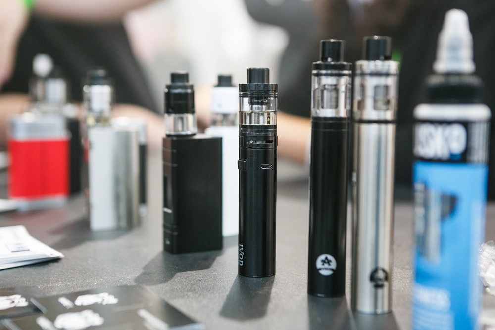 Detailed display of various advanced mod-style and pen vapes, featuring nicotine pods tulsa, alongside e-liquid bottles.