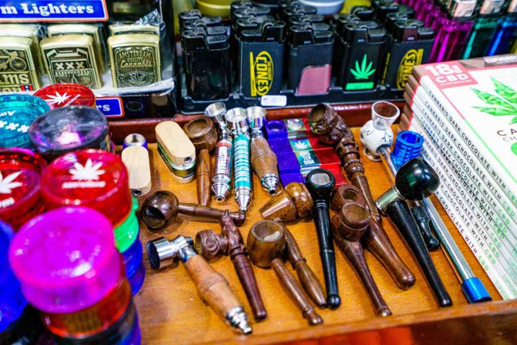 Assorted wooden pipes, metal grinders, and CBD chocolate at a head shop Houston for premium smoking accessories.