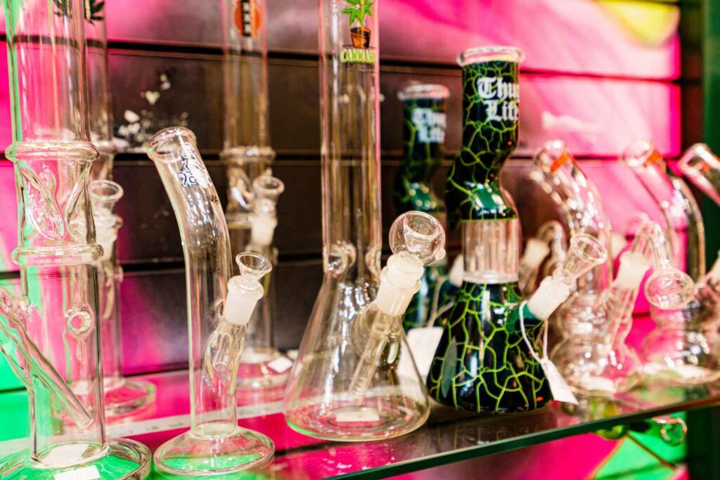 Large beaker bongs and scientific glass water pipes on a glass shelf at a top rated head shop Houston location.