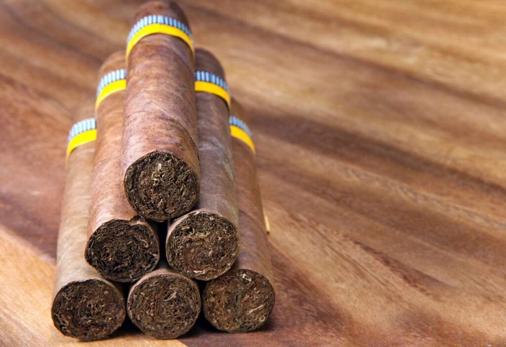 A pyramid stack of luxury banded cigars on a wood table, perfect for a smoke shop Sapulpa showcase.