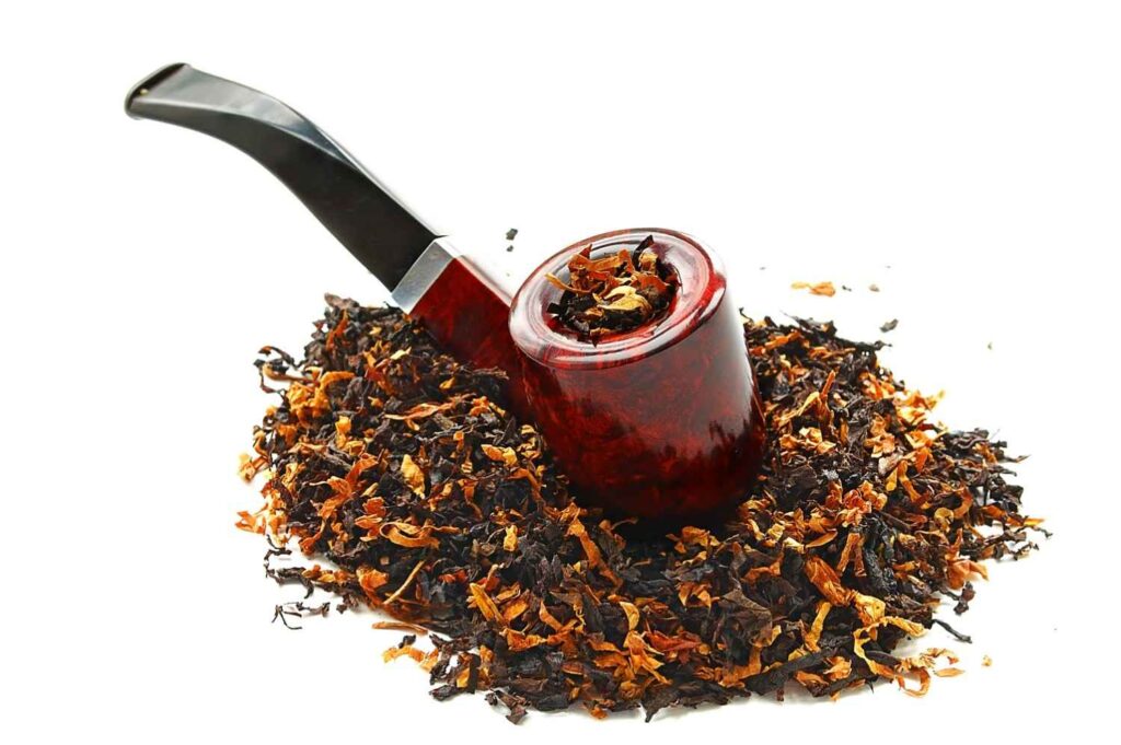 Classic wooden smoking pipe filled with premium loose leaf blend on a pile of blend from a tobacco shop Houston. 