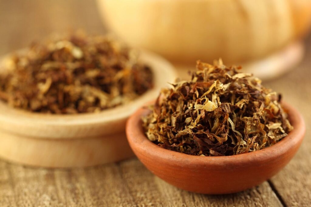 Premium loose leaf tobacco blend in a small clay bowl, perfect for rolling at your local tobacco store sapulpa.