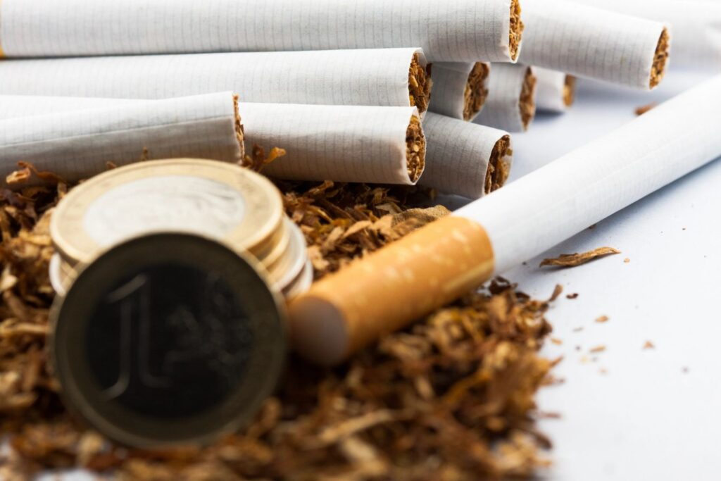 Close up of filtered cigarettes and coins representing affordable pricing at a leading tobacco store Tulsa shop.