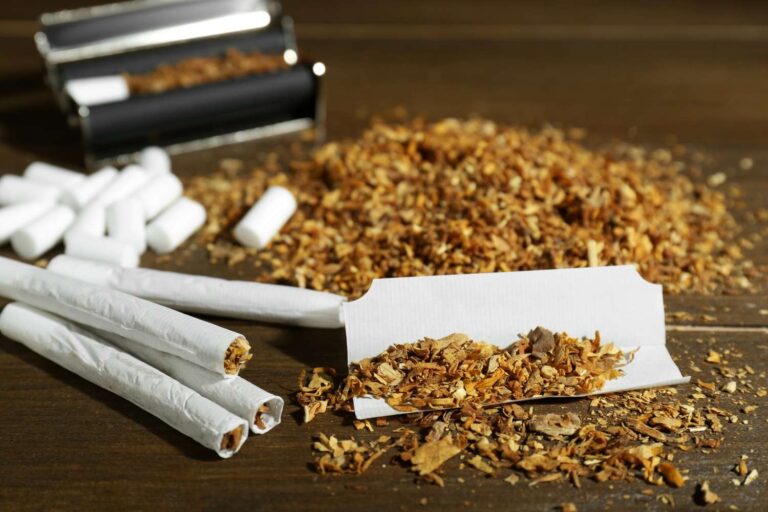 Hand rolling tobacco with white filter tips and a rolling machine from a local tobacco store Tulsa shop supply.