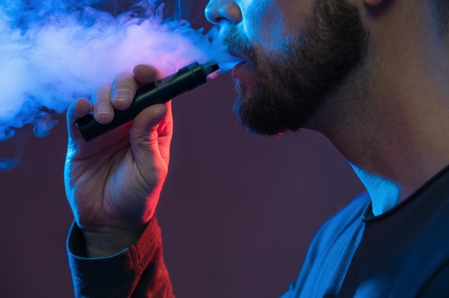 A man using a vape device with vapor clouds, highlighting high-quality nicotine pods Tulsa shop enthusiasts prefer.