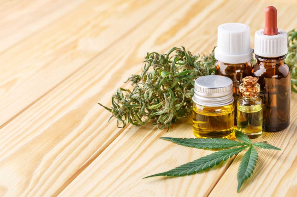 Premium organic medical oil droppers and fresh cannabis leaves featured at a cbd shop Tulsa.