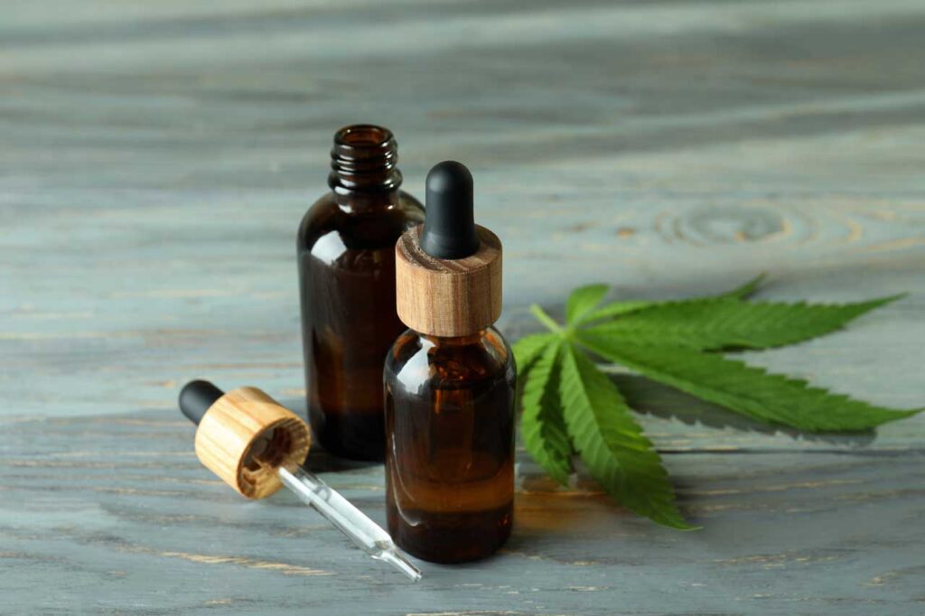 High-quality herbal oil tinctures and a raw leaf on a wooden table from a premium CBD shop Tulsa.