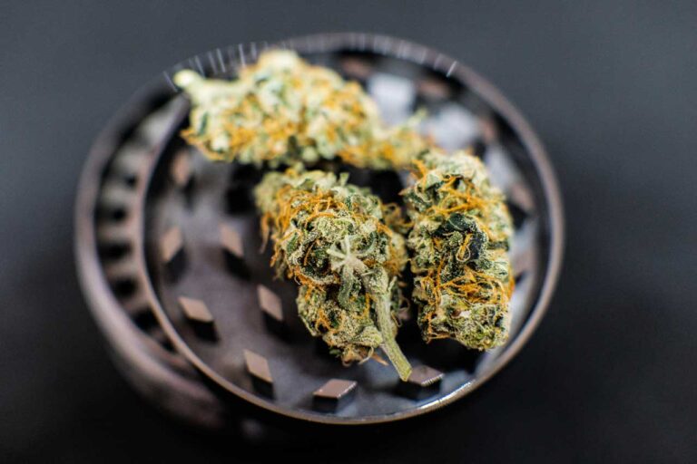 Premium hemp flower on a metal grinder from a top delta 8 store Tulsa option for quality cannabis products.