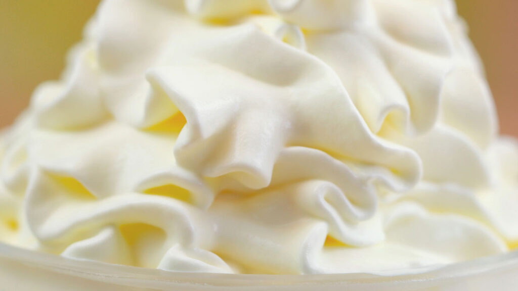 Macro view of a fluffy pile of fresh n20 whipped cream Owasso with perfectly smooth ribbons and rich texture.