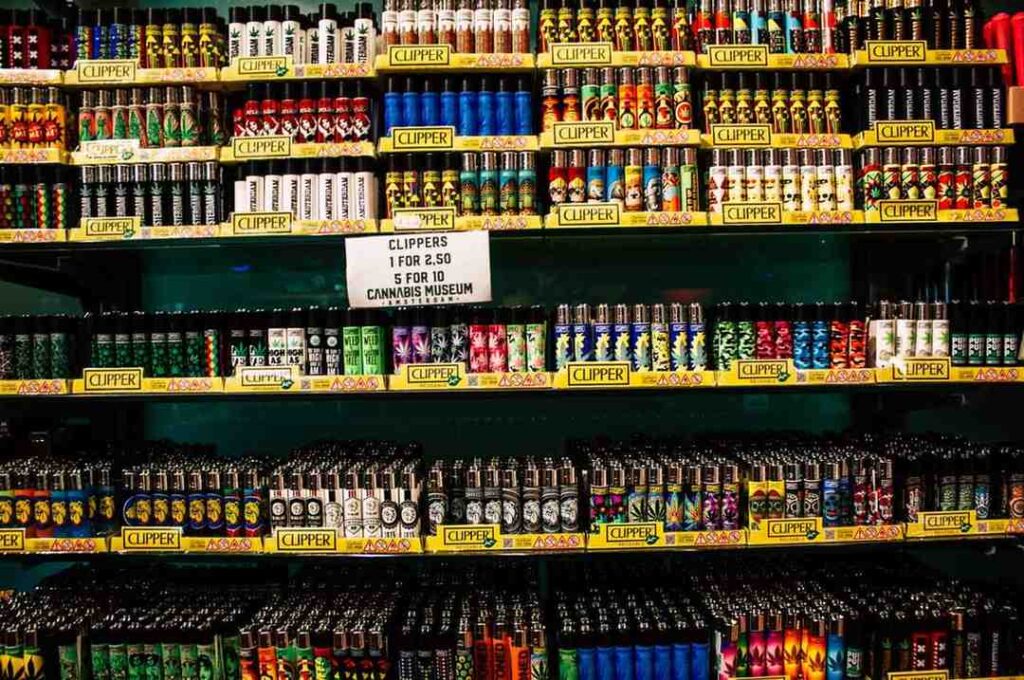 Massive Clipper lighter display rack with colorful custom designs at a smoke shop Tulsa cannabis museum retail shelf.
