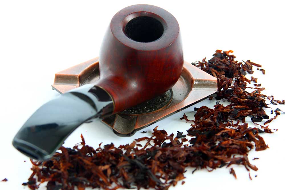 A classic wooden smoking pipe and loose tobacco, bridging classic traditions with modern vape store Houston flavors.