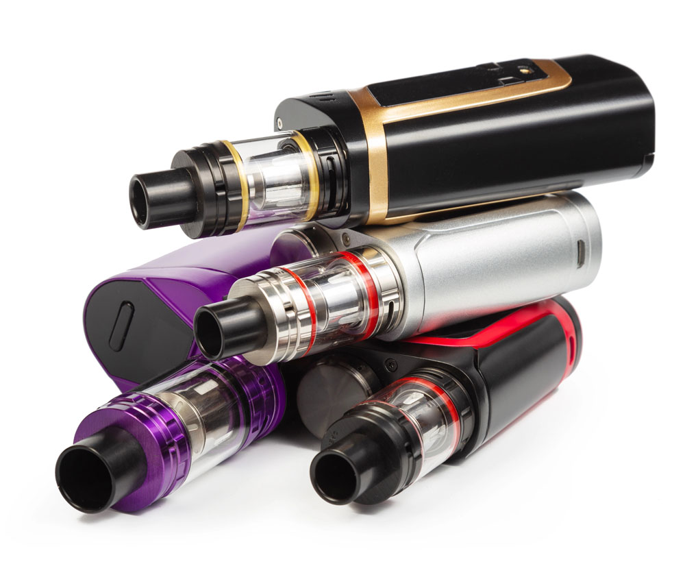 A stacked collection of colorful vape supplies Sapulpa box mods, adjustable tanks, and rebuildable atomizers.
